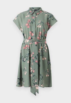 Knap-op skjortekjole i grønne stof med blomsterprint i pink og mørkegrøn. Har korte ærmer og en knyttet taljeaccent.