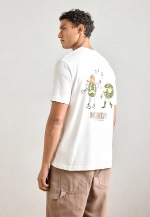 Witte katoenen T-shirt met een grafische print op de achterkant met twee cartoonachtige globussen die accessoires dragen en de tekst "HOWDY."