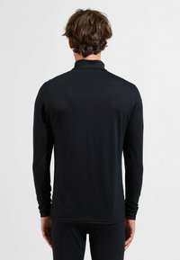 Schwarzes Langarmtop aus weichem, leichtem Stoff. Mit hohem Kragen und enganliegenden Ärmeln, hat eine glatte Textur und ein minimalistisches Design.