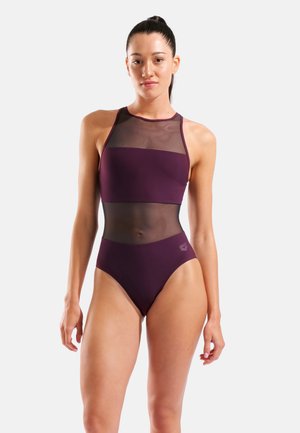 Vínové jednodílné plavky s průhlednými síťovanými panely, vysokým výstřihem a vysokým střihem nohavic. Hladká tkanina s jemným logem na straně.