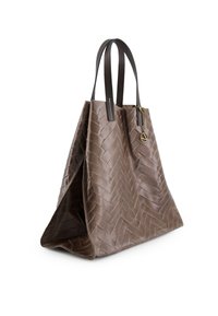 Brown woven tote bag with a textured herringbone pattern, leather handles, and a metal accent. Sturdy shape with open top design.
