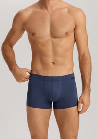 Boxer ajustados de color azul marino fabricados con tejido suave, con una cinturilla elástica y un detalle de costura en contraste, diseño ajustado para mayor comodidad.
