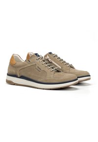 Zapatillas de ante beige con acentos de malla, que cuentan con un talón de cuero en color marrón, cordones grises y una cremallera lateral decorativa. La suela de goma proporciona agarre.