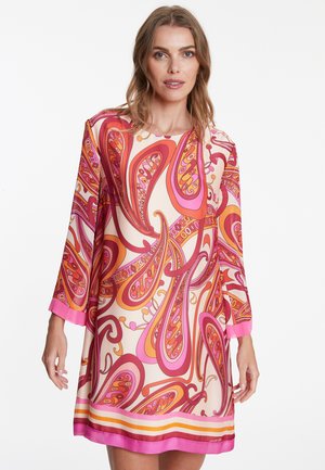 Korte mouw jurk van lichtgewicht stof met een levendig paisleypatroon in roze, oranje en crème, met een gegolfde zoom en contrasterende manchetten.