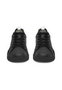 Melni zemi tenisa apavi ar melnām šņorēm, baltām papēžu cilpiņām un "G-STAR ORIGINALS" zīmolu uz mēles, priekšējais skats uz baltā fona.