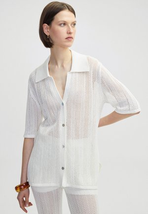 White, mesh knit shirt with short sleeves, button-down front, and a wide collar. Features a transparent texture and subtle horizontal stripes.