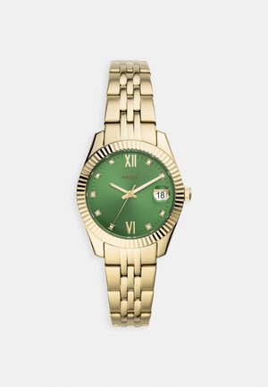 Montre en métal doré avec cadran vert, chiffres romains à 12 et 6, index heures en diamant et fenêtre de date réglée sur 18 côté droit.