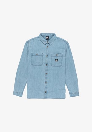 Hellblaues Denimhemd mit Knopfleiste, spitzem Kragen, zwei Brusttaschen, gestickten Details und einem kleinen Logosticker nahe der linken Tasche.