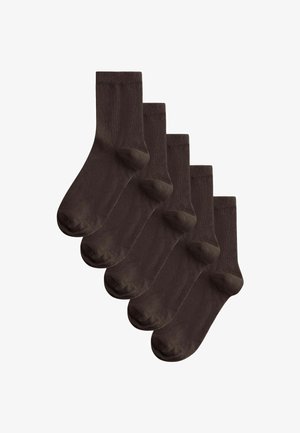 Päť párov jednofarebných tmavohnedých ponožiek do výšky lýtka usporiadaných vedľa seba na bielom pozadí.