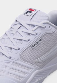 Λευκό αθλητικό παπούτσι FILA AXILUS-FX με ανώτερο μέρος από δίχτυ, πλαστικές επικαλύψεις και λευκά κορδόνια, με λογότυπα της μάρκας στη γλώσσα και στην πλαϊνή επιφάνεια.