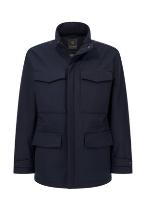 Veste bleu marine en tissu résistant, dotée d'un col montant, de quatre poches à l'avant et d'une fermeture à boutons. Texture lisse avec un design minimaliste.