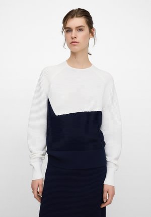 Geribbelde sweatshirt in wit en marineblauw, met een geometrisch kleurblokontwerp. Lange mouwen met aansluitende manchetten, gestructureerde stof en een comfortabele pasvorm.