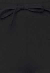 Svarta joggingbyxor med dragsko i midjan, slät yta och sydda detaljer. Tyget är mjukt och stretchigt för komfort.