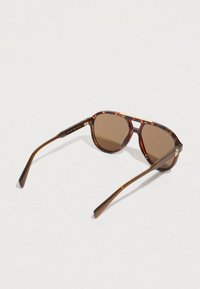 Teknősbéka mintás napszemüveg barna tónusú lencsékkel, klasszikus kerek formával, vékony barna szárakkal és finom arany színű díszítésekkel.