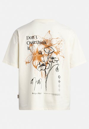 Kremfarvet bomulds-T-shirt med sort blomsterlinjekunst med orange accenter og tekst, korte ærmer og en afslappet pasform.