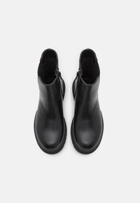 Bottines en cuir noir avec une finition lisse, dotées de zips sur les côtés, de bouts ronds et de semelles texturées pour une bonne adhérence.