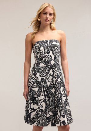 Rochie fără bretele, alb-negru, cu un model paisley, corset ajustat și fustă evazată. Confecționată dintr-un material texturat, neted.