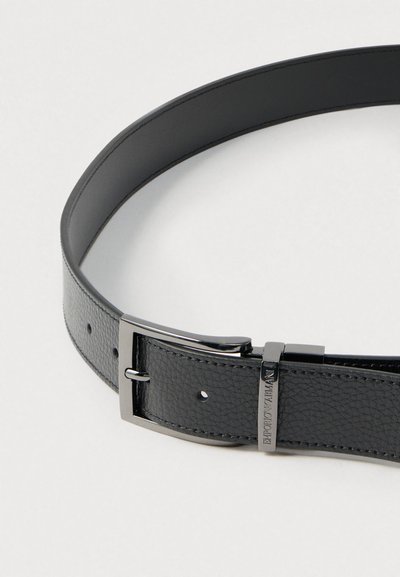 Μαύρη δερμάτινη ζώνη με υφή, ασημένια μεταλλική πόρπη και ρυθμιζόμενες τρύπες. Διαθέτει κομψό σχέδιο και καθαρές άκρες.