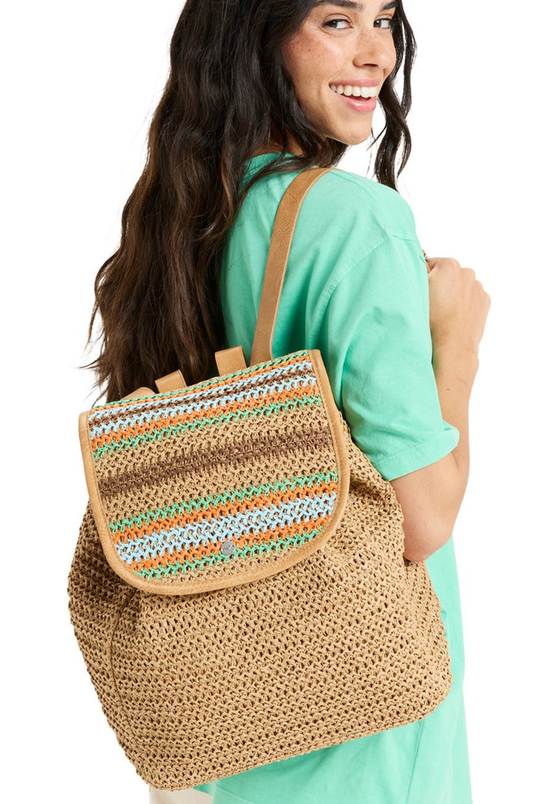 Woven straw backpack with a multicolored striped flap, tan shoulder straps, and a rounded shape. Features a snap closure and textured finish.