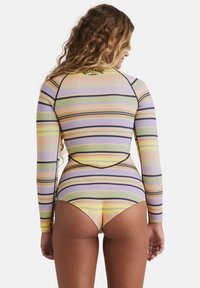 Maglia a maniche lunghe con protezione solare, caratterizzata da strisce verticali pastello in viola, giallo e verde, con un design aderente e cuciture a contrasto.