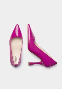 Chaussures à talons hauts fuchsia avec une finition en vernis brillant, des orteils pointus et un talon aiguille mince. L'intérieur est doté d'un revêtement beige.