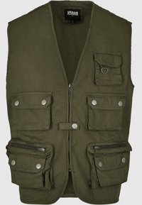 Olive zielona kamizelka wykonana z tkaniny, z zamkiem z przodu, pięcioma kieszeniami, detalami na zatrzaski oraz akcentem w kształcie pierścienia D. Posiada bezrękawnikowy fason.