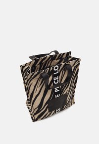 Sac fourre-tout en toile avec imprimé zèbre noir et beige. Doté d'accents en cuir noir et d'un patch logo distinctif, avec des poignées courtes pour le transport.