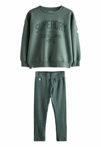 Zaļš džemperis ar "SUPERDAY" logo, apaļu kaklu un ribotām piedurknēm; saskaņotas zaļas legingi ar gludu tekstūru un elastīgu jostasvietu.