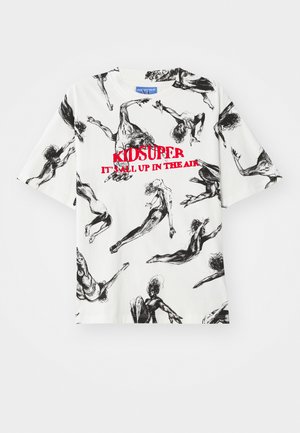T-shirt blanc à manches courtes présentant un motif de croquis noir de figures en mouvement, avec le texte rouge "KIDSUPER C'EST TOUT EN L'AIR" au centre.
