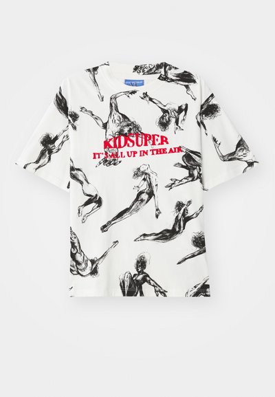 T-shirt branca de mangas curtas com um padrão de esboço preto de figuras em movimento, com o texto vermelho "KIDSUPER IT'S ALL UP IN THE AIR" no centro.