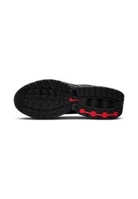 Soletta delle calzature Nike con un design in gomma nera, schemi testurizzati e accenti circolari rossi per trazione e supporto.