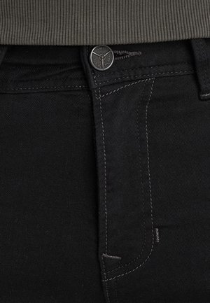 Zwarte denim jeans met een aansluitend ontwerp, zichtbare muntzak, contrasterende grijze stiksels en een gemerkte zwarte metalen knoop.