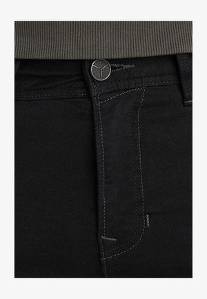 Zwarte denim jeans met een aansluitend ontwerp, zichtbare muntzak, contrasterende grijze stiksels en een gemerkte zwarte metalen knoop.