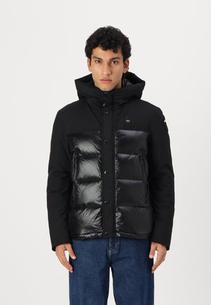 Schwarze Pufferjacke mit mattem Obermaterial und glänzendem, ge quiltetem unteren Bereich, Kapuze, Druckknopfverschluss und zwei seitlichen Reißverschlusstaschen.