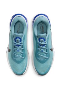 Světle modré sportovní boty s texturovaným svrchním materiálem z síťoviny, černým logem Nike, modrými akcenty a bílou podrážkou. Obsahuje šňůrky a komfortní polstrování.