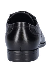 Zwarte leren schoen met een gladde textuur, ronde neus en een lage hak. Heeft subtiele stiksels langs de bovenkant.