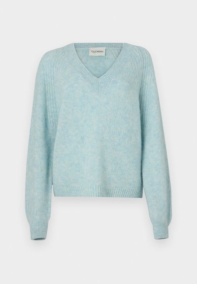 Jasnoniebieski sweter z dekoltem w kształcie litery V i długimi rękawami. Miękka tekstura i ściągacze przy mankietach. Luźny krój z krótkim końcem.