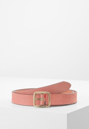 Różowy skórzany pasek z kwadratową mosiężną klamrą z wygrawerowanym napisem „Hilfiger” oraz małym czerwono-niebieskim przeszyciem w pobliżu klamry.