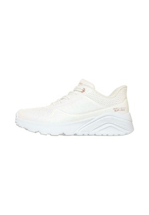Zapatilla deportiva blanca Skechers tipo slip-on con cordones delanteros y suela gruesa y texturizada, mostrada desde el lado derecho sobre fondo blanco.