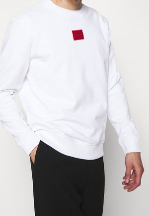 Witte sweatshirt met een ronde hals, ribbelmanchetten en -zoom. Bevat een klein rood vierkant logo op de borst. Gemaakt van zacht katoen.