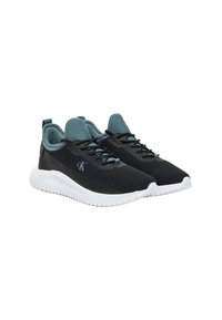 Zapatillas deportivas negras con detalles en verde azulado, parte superior ligera y suave, cierre con cordones y suela blanca con amortiguación. Logo visible en el lado.