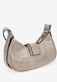 Bolso hobo de cuero beige con forma curvada, acentos negros, herrajes en plata y un bolsillo con cremallera. Presenta una correa estructurada y un acabado texturizado.