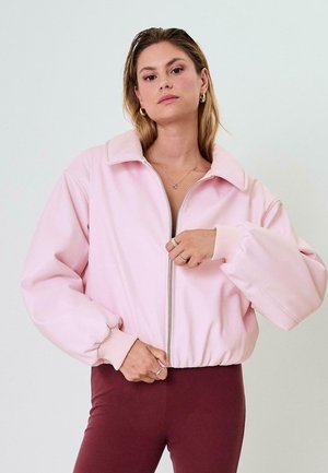 Giacca bomber rosa chiaro con un ampio colletto, chiusura con zip e polsini a coste. Il tessuto sembra morbido con una finitura leggermente lucida.