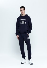 Felpa con cappuccio e pantaloni jogger in marinara di FREDDY, con testo del logo bianco. L'outfit ha una vestibilità comoda ed è realizzato in un tessuto morbido.