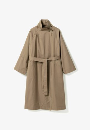 Długi beżowy trencz z szerokimi rękawami, wysokim kołnierzem zapinanym na guzik oraz dopasowanym paskiem z tkaniny przewiązanym w talii.