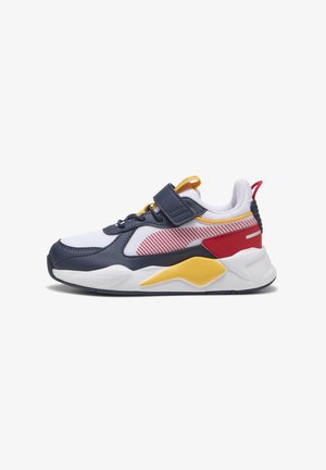 Chaussure de sport avec une tige en mesh bleu marine et blanc, des accents rouges et jaunes, une bande Velcro et une semelle blanche épaisse avec des détails texturés.