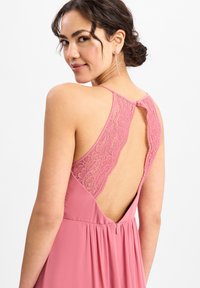 Roze jurk met een kanten rug en verstelbare bandjes, met een keyhole-detail en een vloeiende rok. Zachte textuur en vrouwelijke stijl.