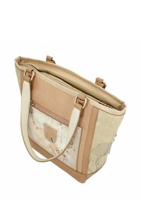 Sac fourre-tout beige avec un tissu texturé et des accents en cuir lisse. Présente un devant à motifs et une poche zippée à l'arrière.