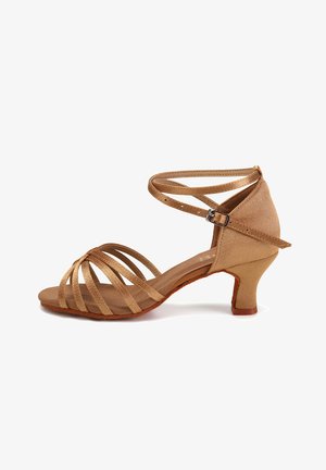 Beżowe sandały na paski z zamkniętą piętą, niskim obcasem w kształcie bloków i skrzyżowanymi paskami na palcach. Wykonane z miękkiego materiału o fakturze przypominającej zamsz.