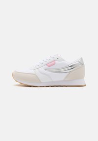 Zapatilla deportiva blanca con acentos en rosa y plata, materiales de malla y ante, punta redonda y suela de goma con un patrón de textura.